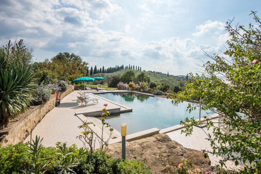 a swimming pool in a garden with trees and bushes at La Farneta in Monteriggioni