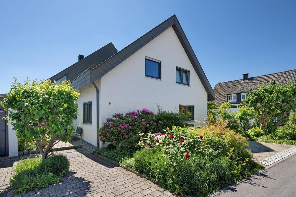 a white house with flowers in front of it at Ferienwohnung Lange in Waldstetten