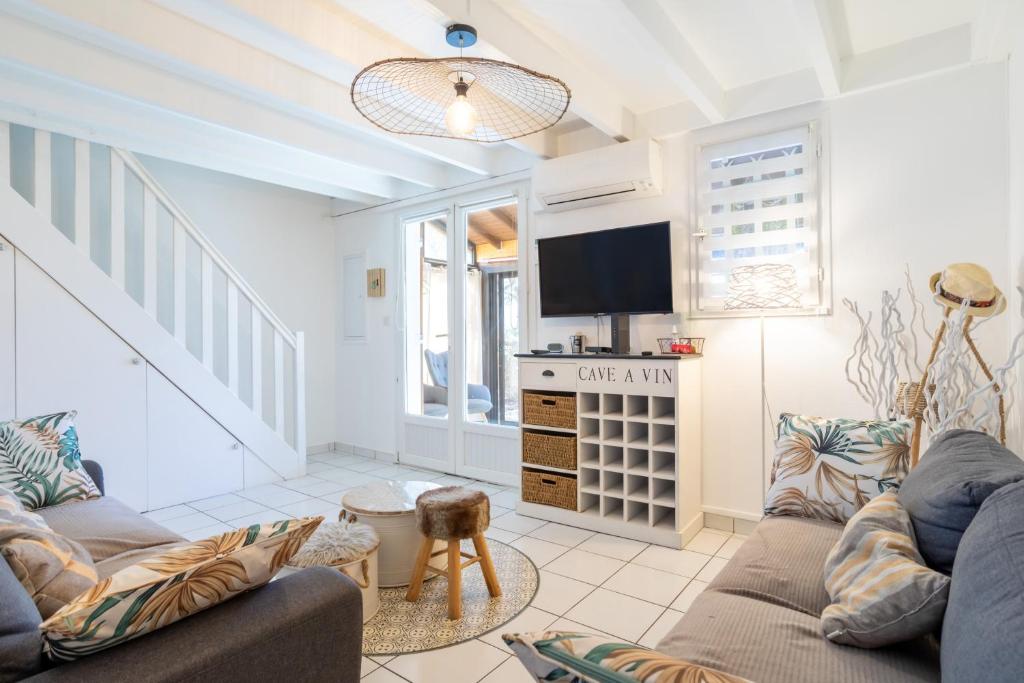 a living room with two couches and a tv at Maison 4 chambres fb112 in Le Barcarès