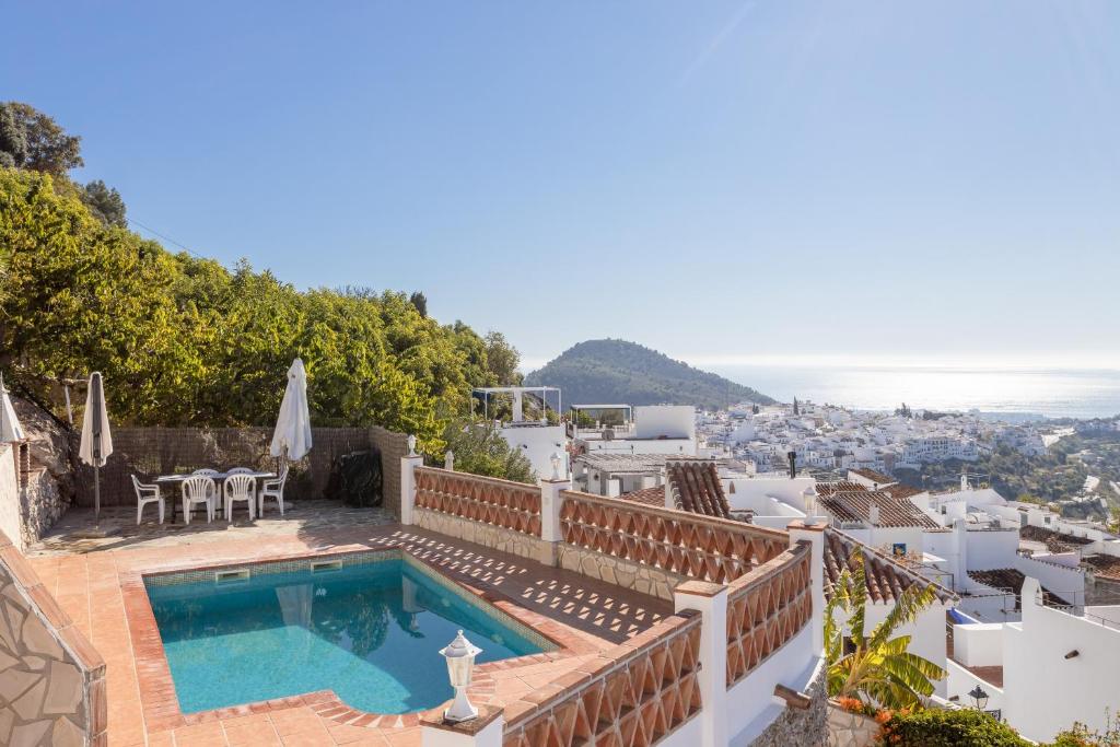 a villa with a swimming pool and a view of the city at Casa rural Villena in Frigiliana