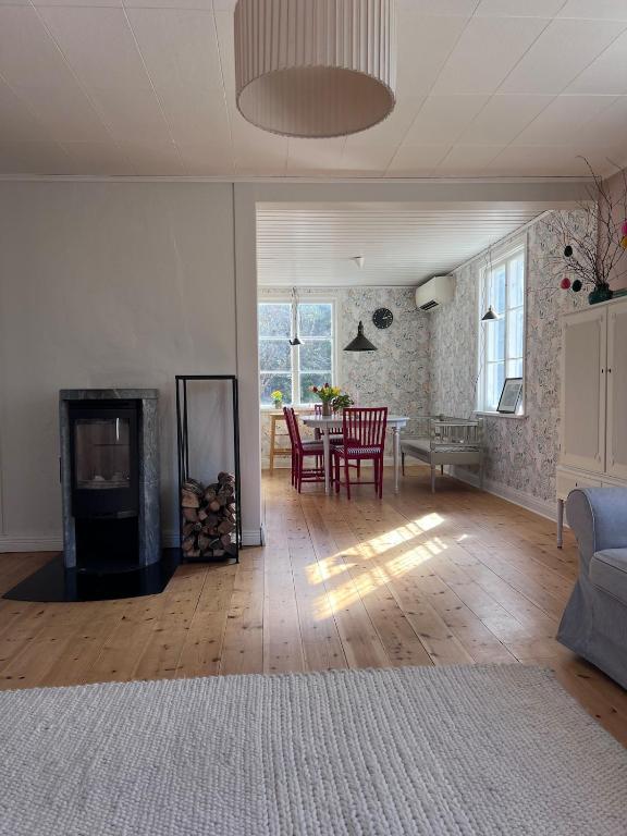 a living room with a fireplace and a table with chairs at Enskilda stugan in Kärsta