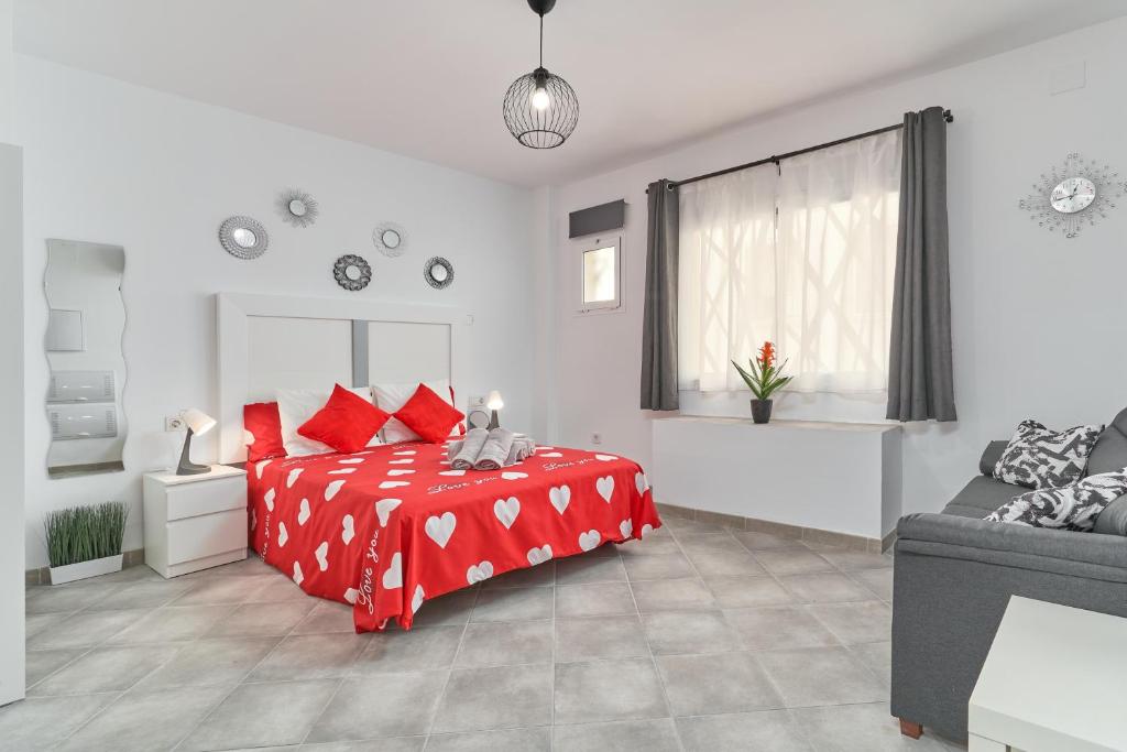 a white bedroom with a red bed and a couch at Nerja Boutique B2 Street level in Nerja