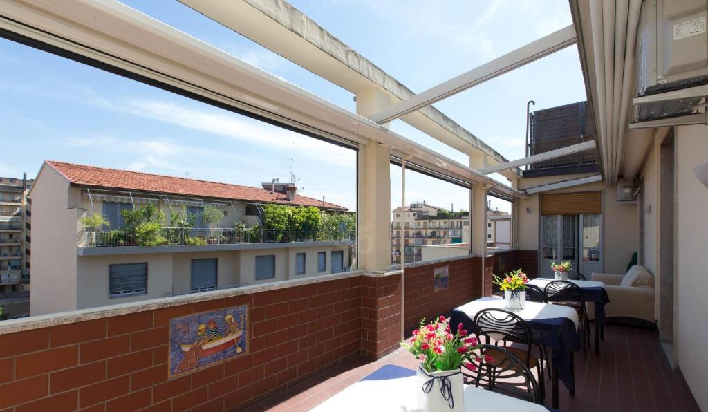 d'un balcon avec des tables, des chaises et des fenêtres. dans l'établissement Il Grillo Di Firenze B&B, à Florence