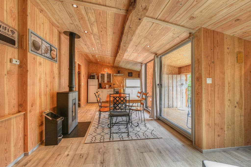 a living room with wood paneling and a dining room at Maison - Le pic du midi in Roquefeuil