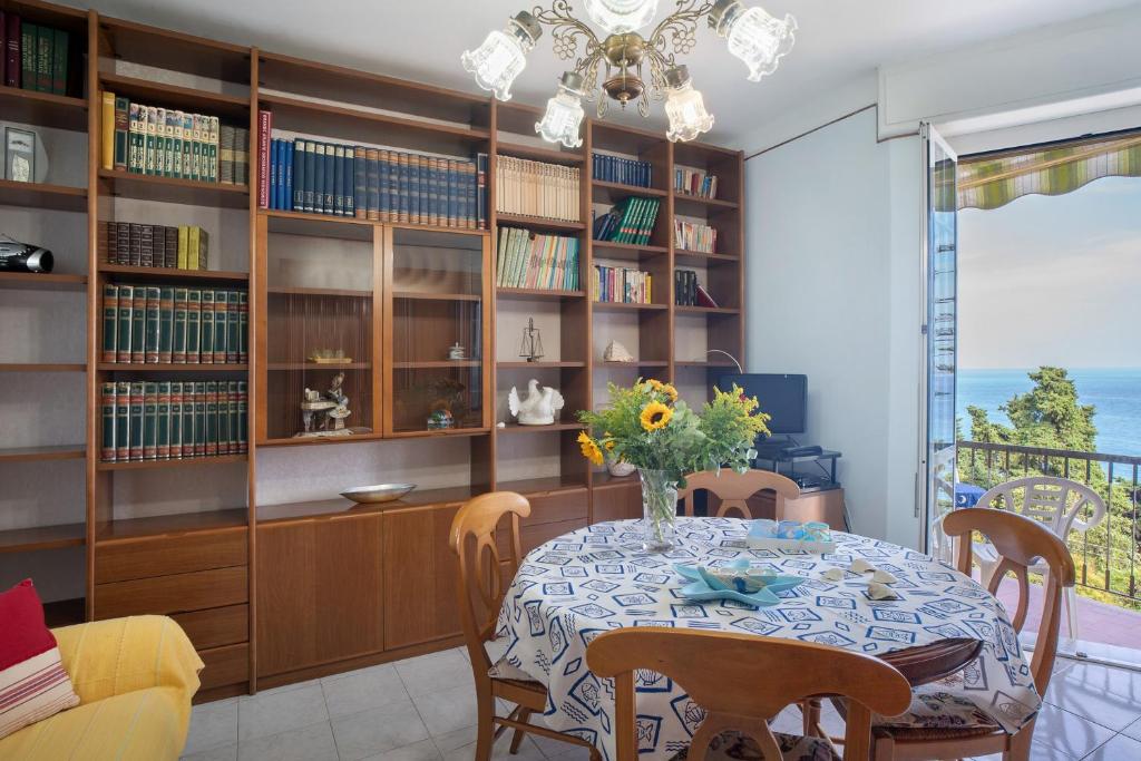 a dining room with a table and bookshelves at La Ca' Di Marì in Costarainera