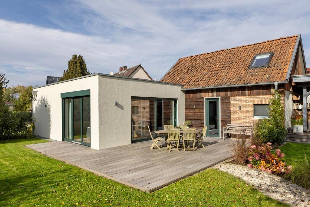 a backyard with a wooden deck and a house at Ferienhaus Buwesch 13 in Nüsttal