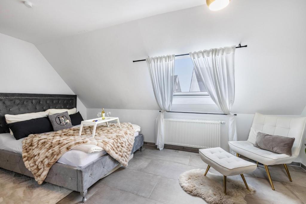 a bedroom with a bed and a chair and a window at Deluxe Apartment in Duisburg