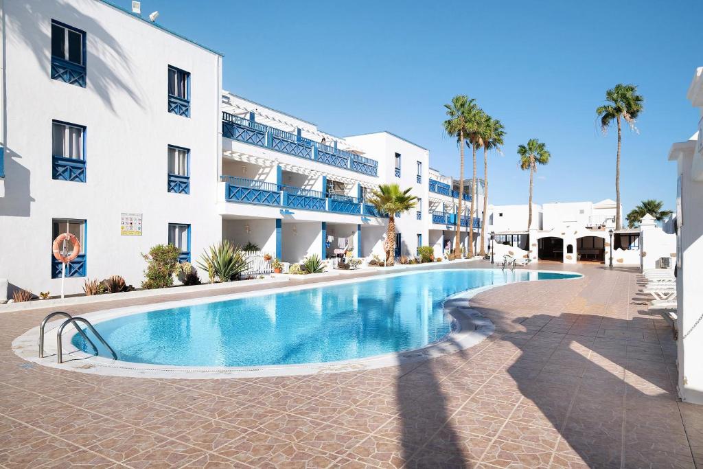 a swimming pool in front of a building at Casa Gloria in Puerto del Carmen