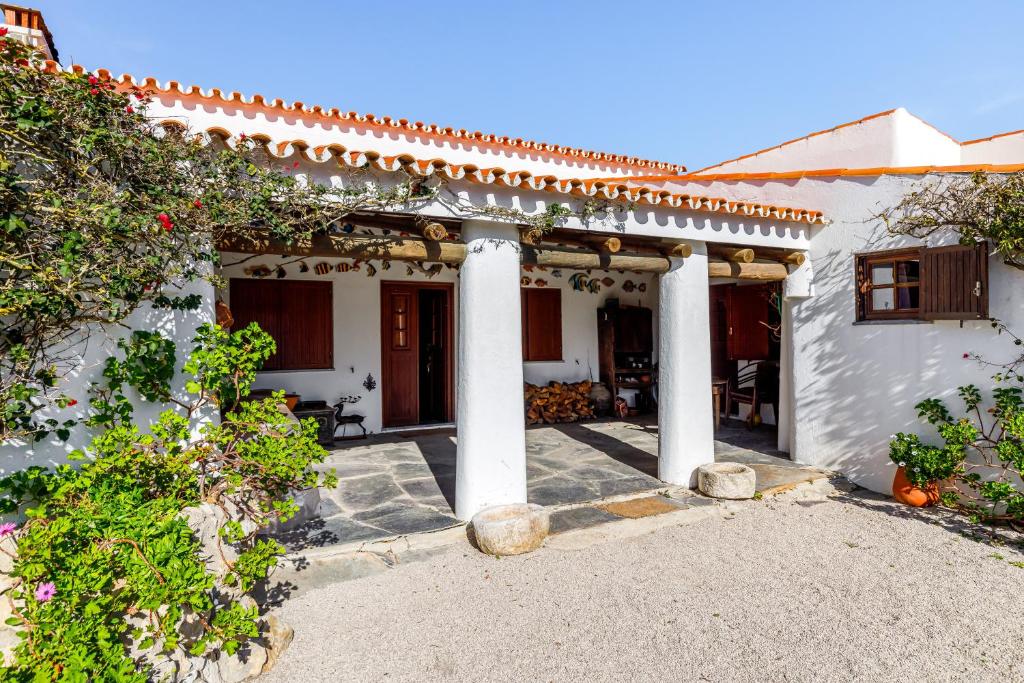 a white house with white columns and plants at Casa do Mar in Sesimbra