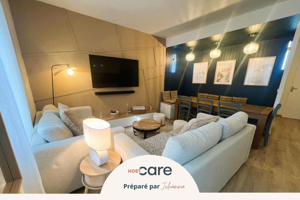 a living room with two white couches and a dining room at Les Trois Mouettes - Grand appartement familial in Saint-Brieuc
