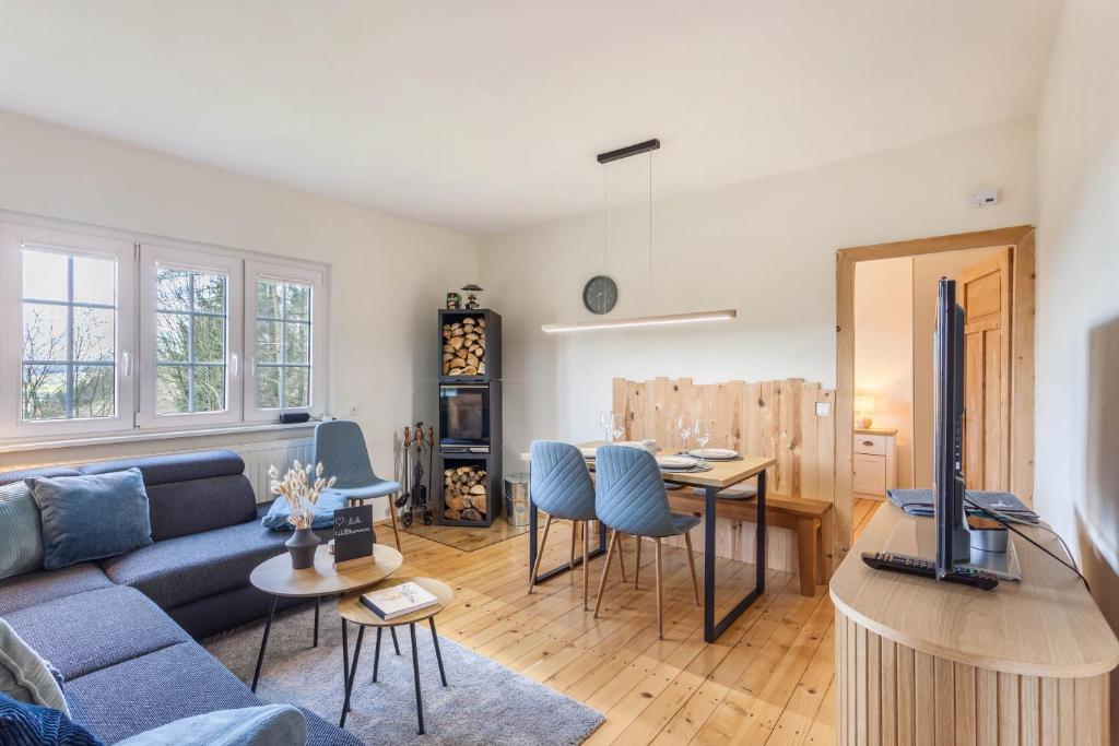 a living room with a blue couch and a table at Homertstuebchen in Eslohe