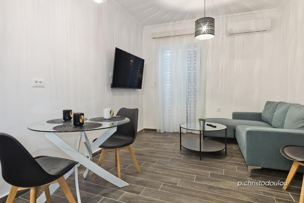 a living room with a couch and a table and chairs at Helios Apartment 2 in Karpathos