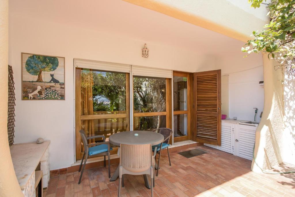 a room with a table and chairs and windows at Studio with Private Garden in Lagos