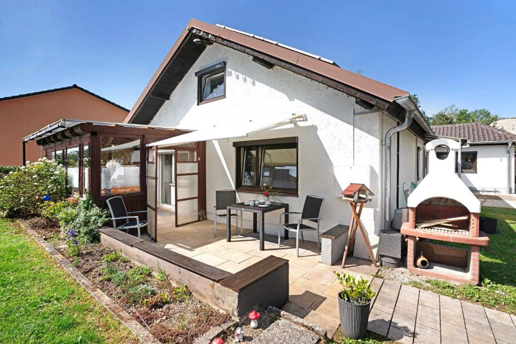 a house with a patio with a table and chairs at Wohnung zum Hirschen in Gräfelfing