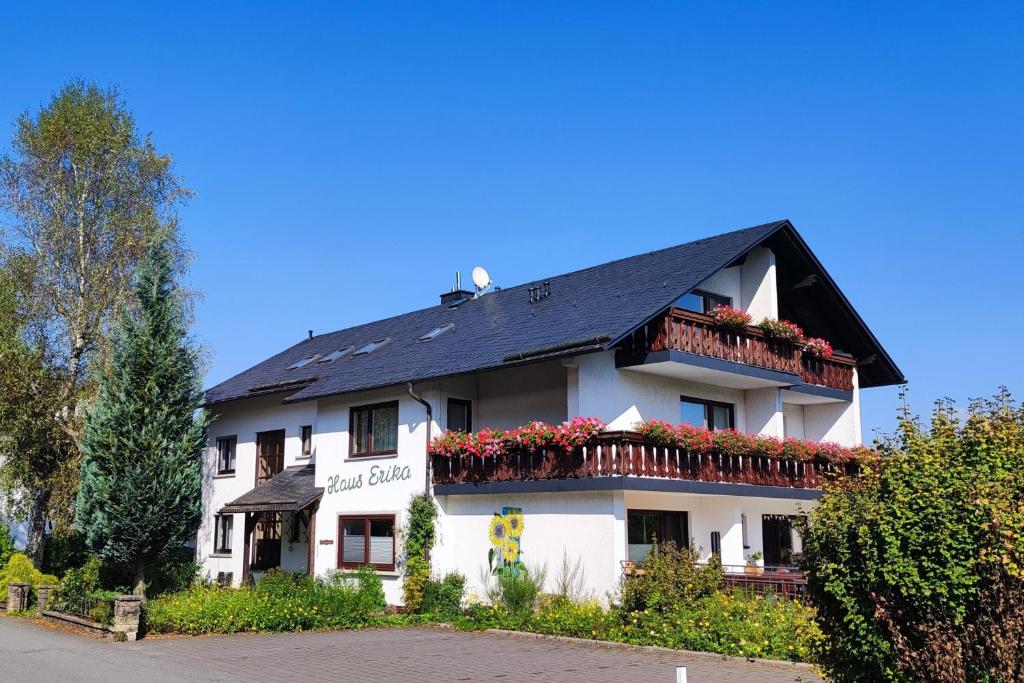 a white building with flowers on the balconies at Haus Erika in Stryck