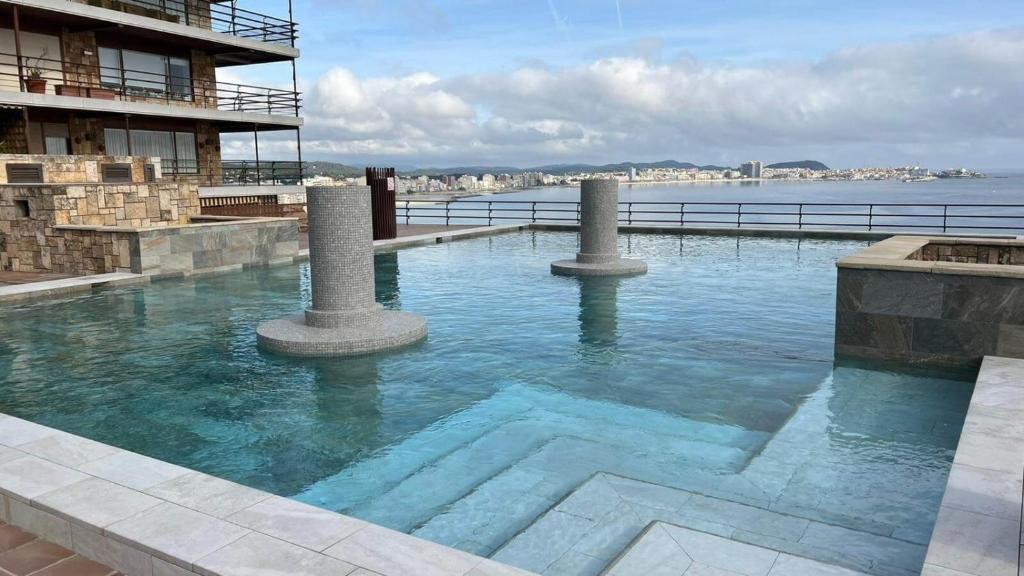 a swimming pool with two pillars in the water at Eden Mar Calonge Girona in Calonge