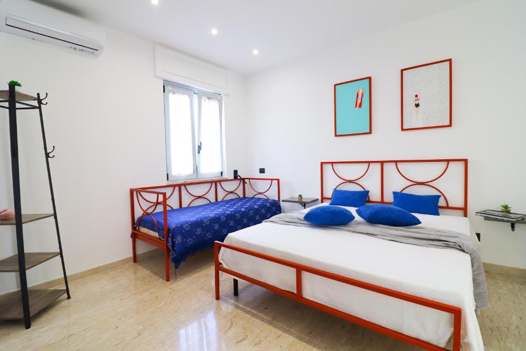 a bedroom with a bed with blue pillows and a ladder at Casa Malika a Otranto in Otranto