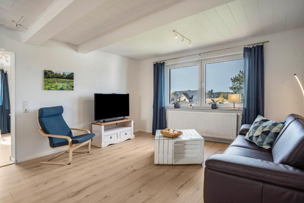 a living room with a couch and a television at 5 Sterne Ferienwohnung Boddenblick in Glowe