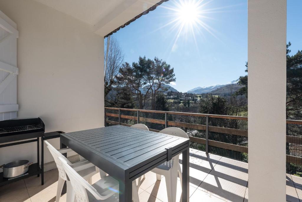 a table and chairs on a balcony with a view at Domaine de l'Arbizon in Bagnères-de-Bigorre