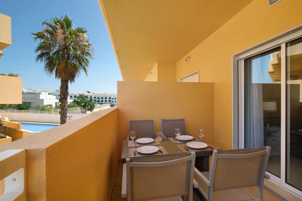 a dining room with a table and chairs on a balcony at Royal Cabanas Golf 85 in Cabanas de Tavira