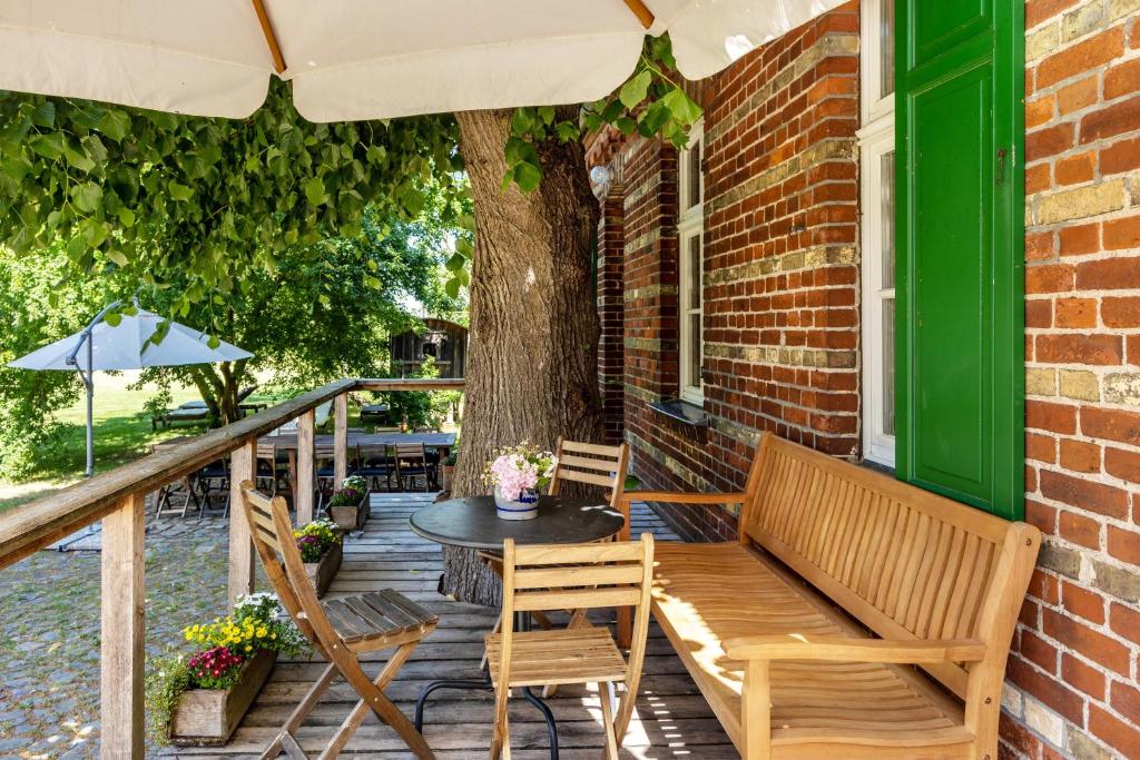 a patio with a table and chairs and an umbrella at Der Flusshof, Ferienhaus in Werben