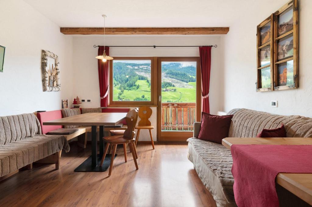 a living room with a table and a couch at Paracia App La Vedla in Badia