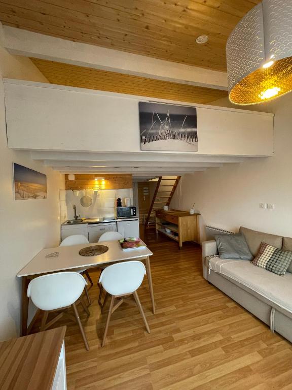 a living room with a table and chairs and a couch at La Tomate Surfeuse 1 in Hourtin