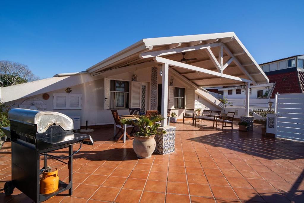 a patio with awning and a grill on a house at Casa Vacanza Giugiò in Giardini Naxos
