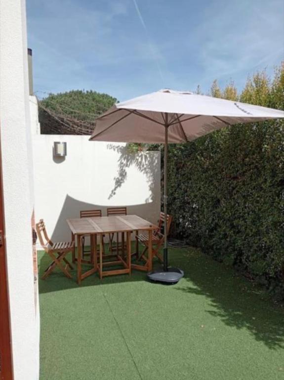 an umbrella and a table and chairs on a patio at Soltroia Beach House in Carvalhal