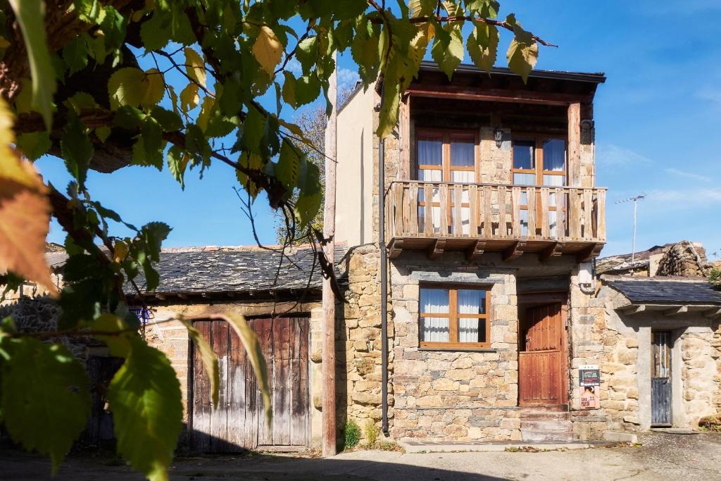 an old stone house with a balcony on top of it at La Casa De Anta in Asturianos