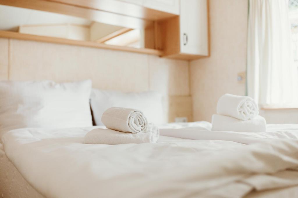 two white towels sitting on top of two beds at Villa Hexenholz in Thale