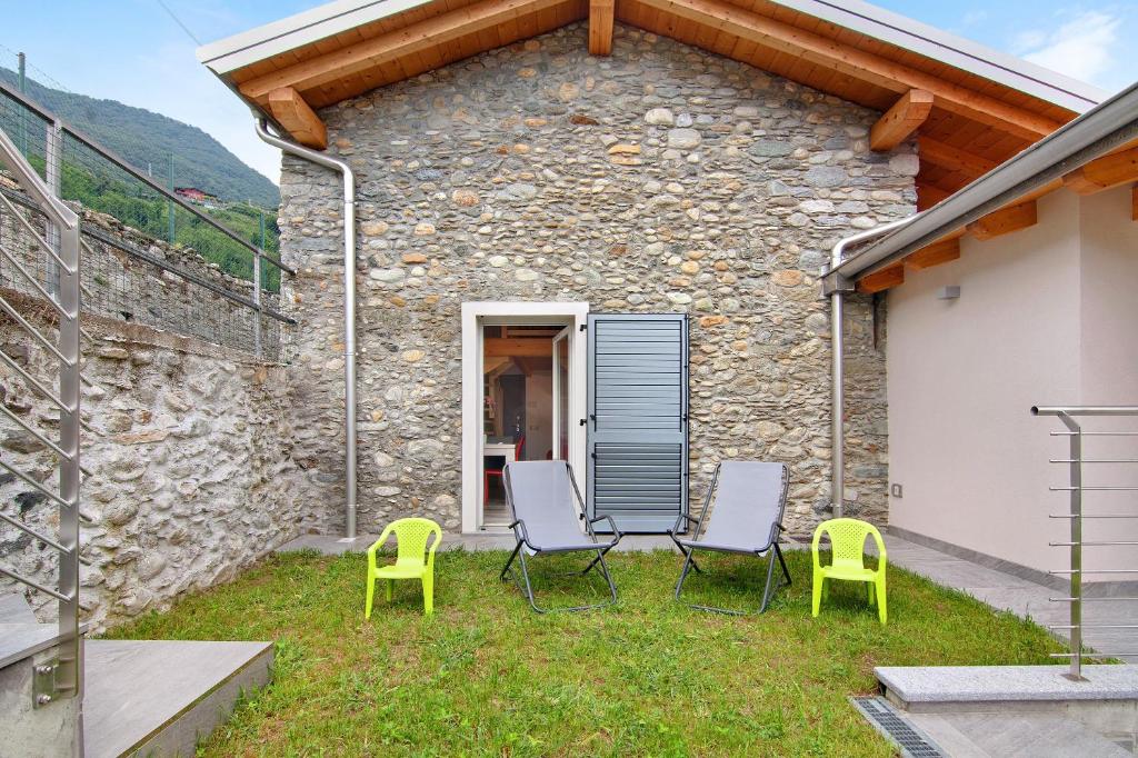 a patio with four chairs and a building at Jack House in Domaso