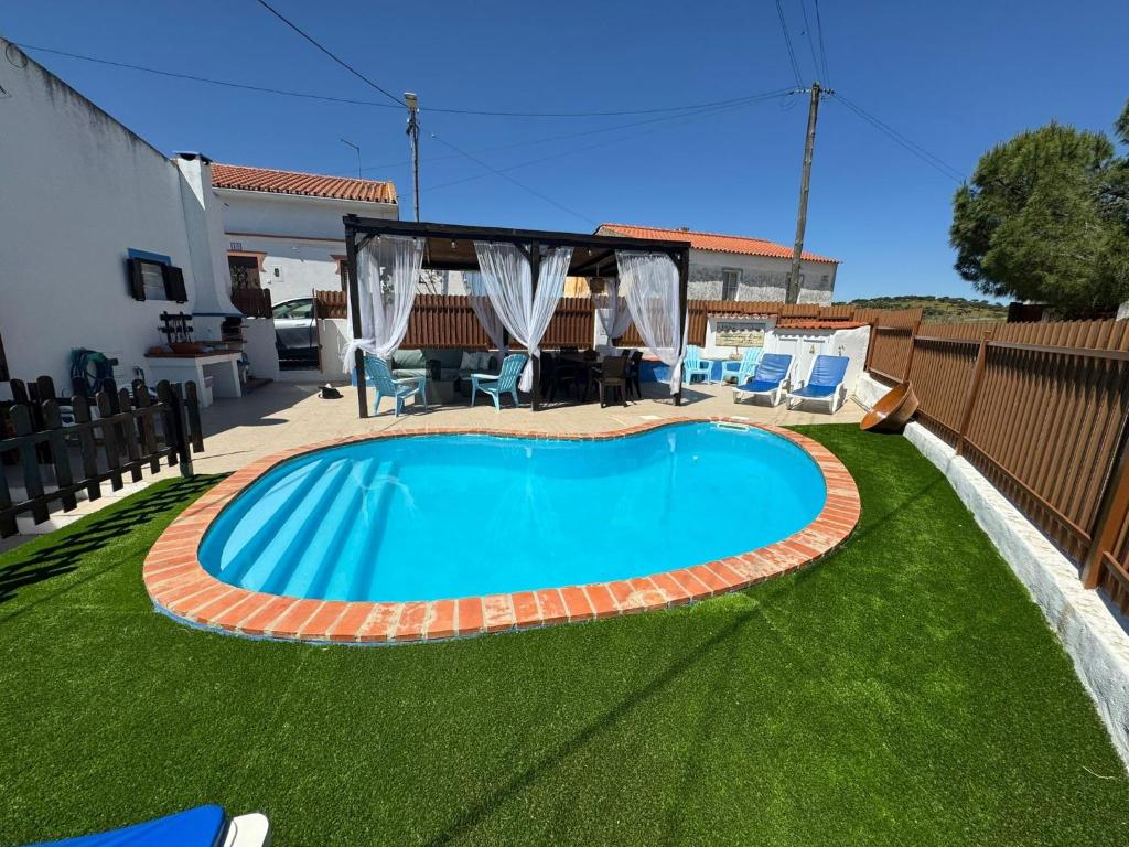 a swimming pool in the middle of a yard at Casa d’ avó Lita in Falcoeiras
