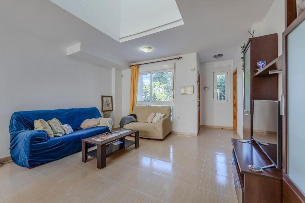 ein Wohnzimmer mit einem blauen Sofa und einem Tisch in der Unterkunft Vera Rambla in Vera