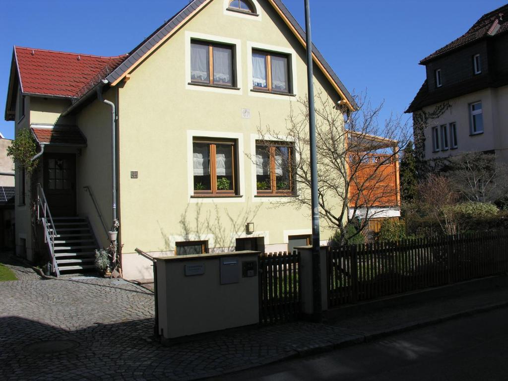 a white house with a fence in front of it at Ferienwohnung Auenweg in Radebeul