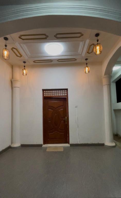 a large room with a wooden door and lights at Hamdan Villa in Dharga Town