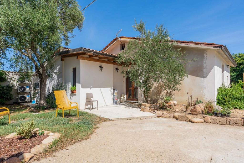 a house with yellow chairs in front of it at Su Carinniu in Villacidro