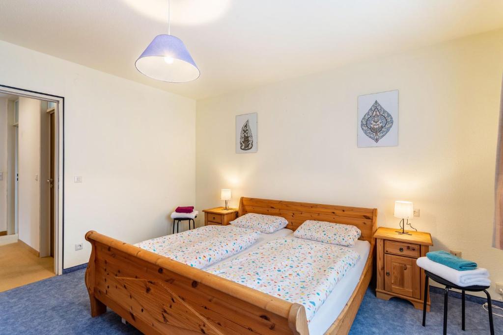 a bedroom with a wooden bed and two night stands at Haus Waldblick in Bad Berleburg