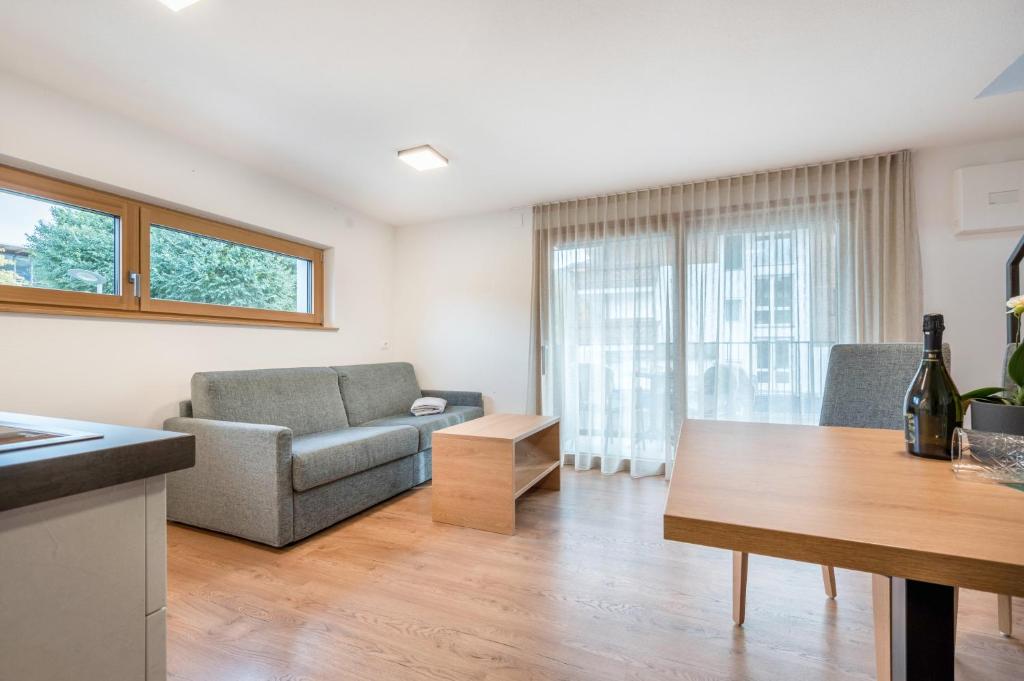 a living room with a couch and a table at App Dolomiten Villa Colli in Valdaora