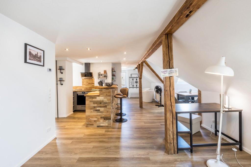 a kitchen and living room with a wooden floor and a table at Eichendorff Loft in Nordhausen
