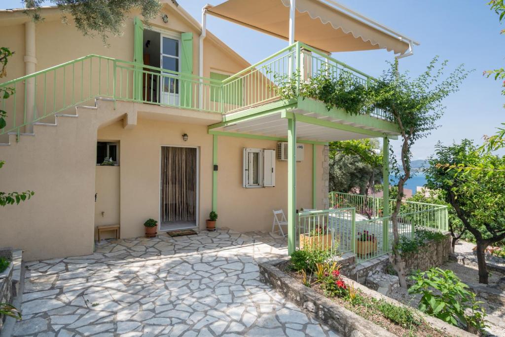 a house with a balcony and a staircase at Nikiana hideaway in Nikiana