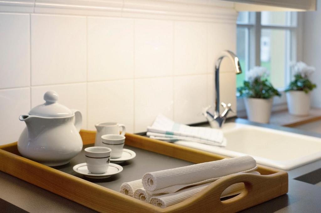 a tray with a tea pot and cups on a kitchen counter at Gut Rattelvitz - Parterre Ost in Gingst