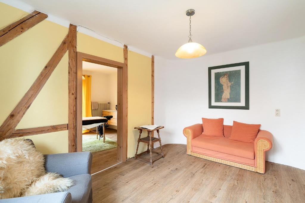 a living room with a couch and a piano at Holzwurm Apartments in Sasbachwalden