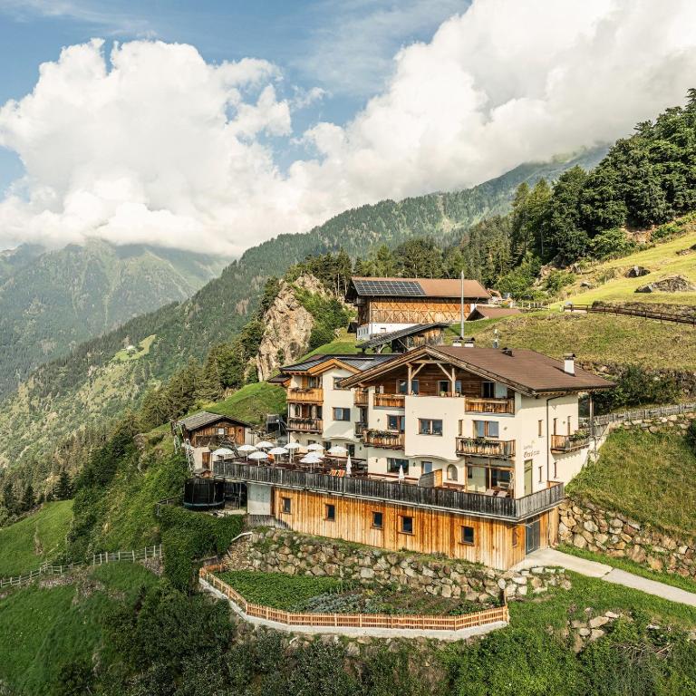 a building on a hill with mountains in the background at Oberplatzer in Lagundo
