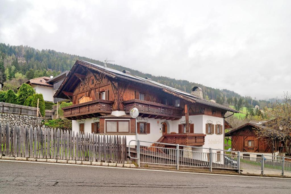 a wooden house with a fence in front of it at Schnellehof in Velturno