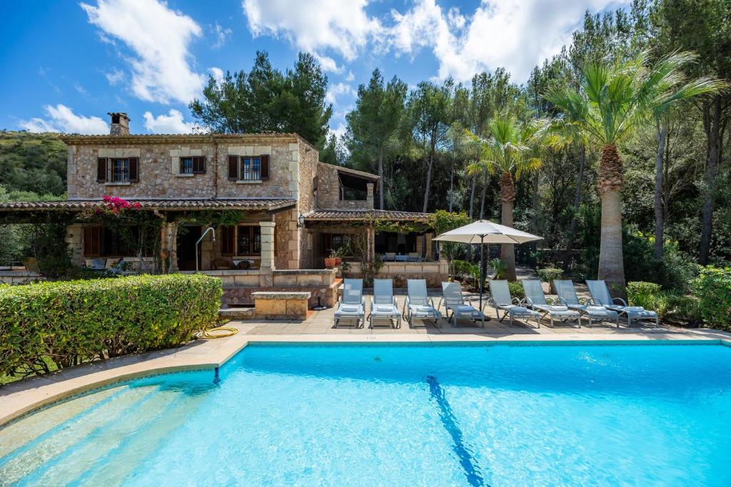 a house with a swimming pool in front of a house at Can Seguinot D'alt in Pollença