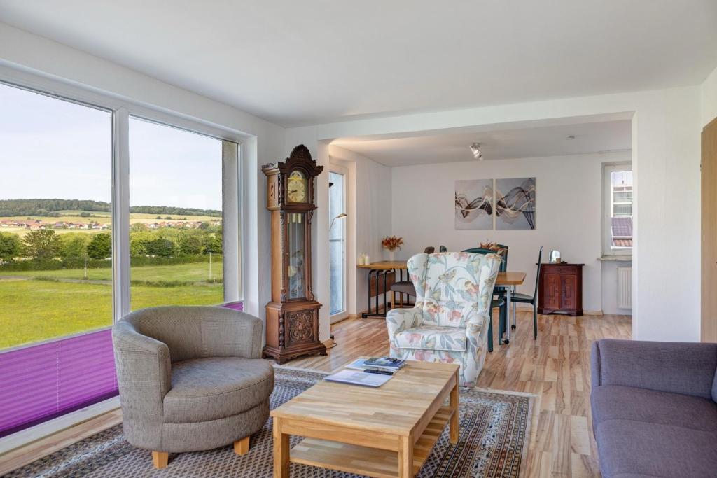a living room with a clock and chairs and a table at Haus Lerchenweg in Bad Wildungen