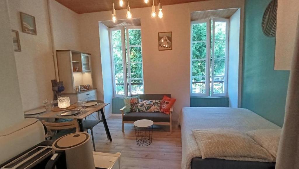 a bedroom with a bed and a desk and a table at Appartement 4 pers Montagne -draps et serviettes non fournis- in Eaux-Bonnes