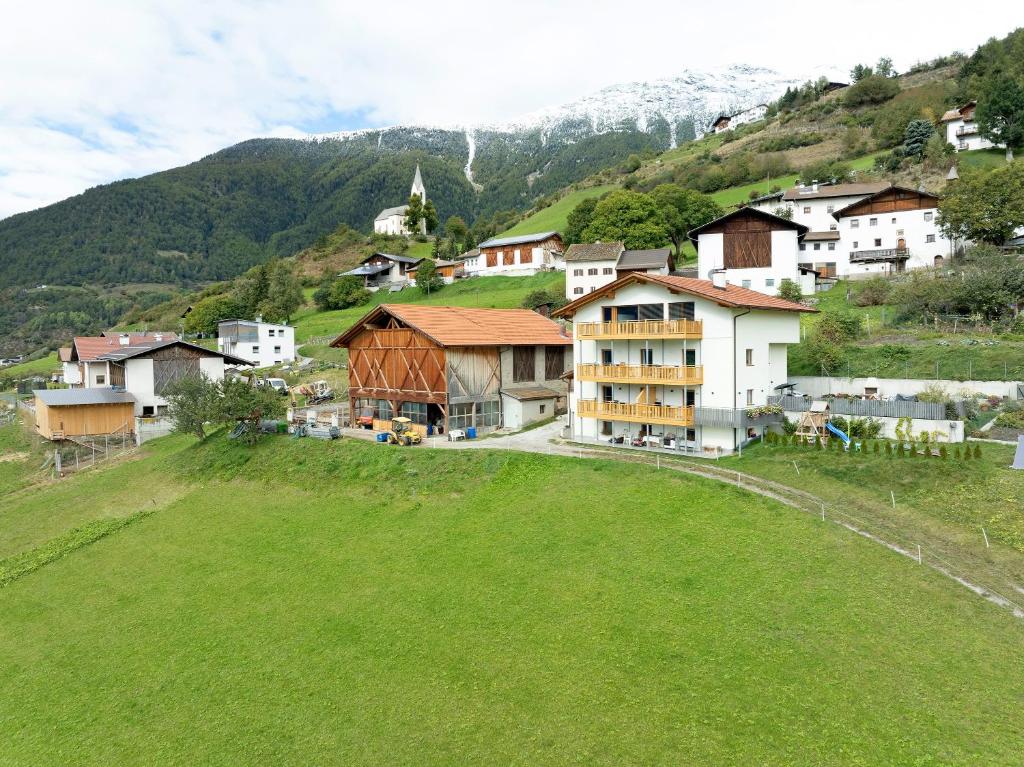 a group of houses on a hill with a green field at Gurschlerhof in Lasa