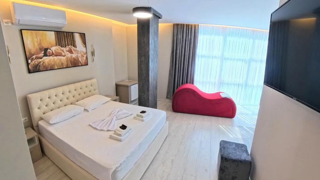 a bedroom with a white bed and a large window at London Restaurant Hotel in Kukës